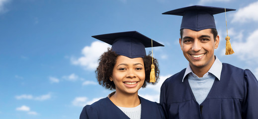 students or bachelors in mortar boards over sky
