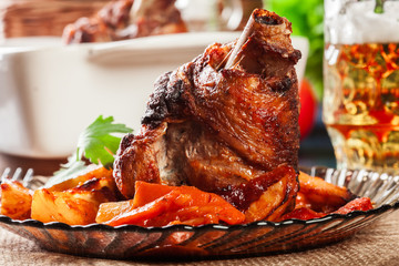 Roasted turkey knuckle with potatoes and vegetable