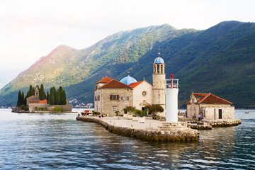 Fjord in Adriatic Sea. Our Lady of the Rock island and Church in Perast on shore of Boka Kotor bay...