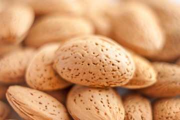 a close up macro shot of lot of almond nuts in the shell with selective focus and beautiful bokeh