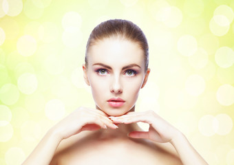 Naklejka premium Portrait of young, beautiful and healthy woman: over yellow background. Healthcare, spa, makeup and face lifting concept.