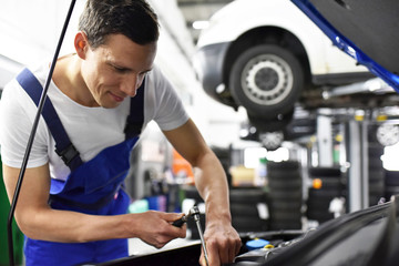 Closeup Automechaniker repariert Fahrzeug in einer Werkstatt // Mechanic repairs vehicle in a...