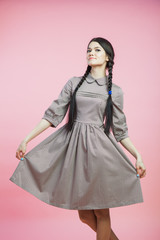 Beautiful woman in retro style dress over pink background