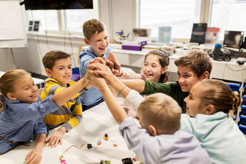 happy children making high five at robotics school