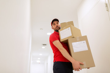 Obraz na płótnie Canvas delivery man with parcel boxes in corridor