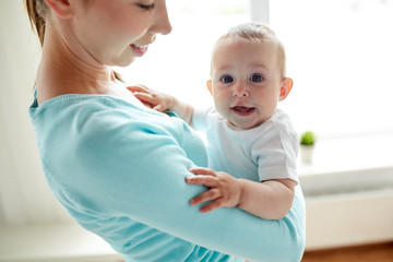 happy young mother with little baby at home