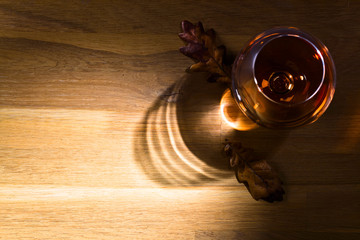 Snifter of brandy and dried oak leaves