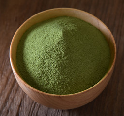 Green tea powder matcha on wooden background