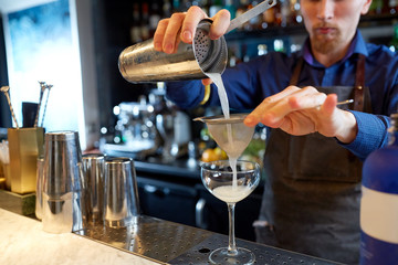 Fototapeta na wymiar bartender with shaker preparing cocktail at bar