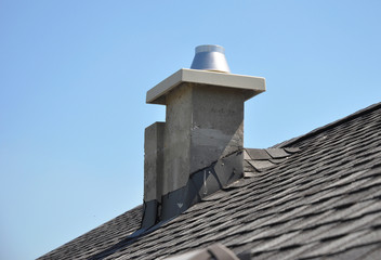 Chimney Repair and Waterproofing asphalt shingles. New modular pumice chimney installation on the house roof. Chimney Linings. Pumice chimney liners.