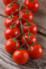 Fresh, ripe cherry tomatoes on an old wooden background