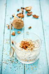 Healthy dietary breakfast - chia pudding with muesli, cereal flakes, walnut and honey in a glass bowl