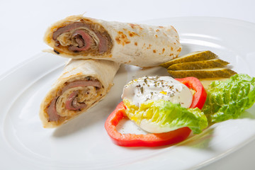Rolls from pita bread stuffed with beef and onion decorated with vegetables