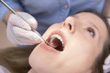 Dentist examining a patient's teeth to the dentist