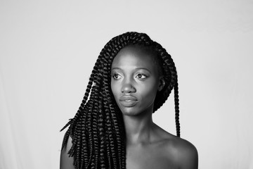 Pretty African girl with braids staring into the distance - obrazy, fototapety, plakaty
