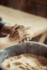 Close up of male potter hands taking clay from a bowl