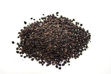 Black granulated dry tea on white