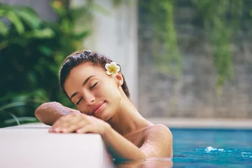 Raamstickers Beauty and body care. Sensual young woman relaxing in outdoor spa swimming pool. © luengo_ua