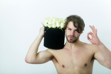 Sexy man showing ok gesture with roses in box