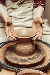 Close up of female hands working on potters wheel