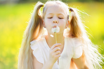 Little blonde girl with dandelion
