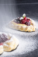 Vanilla Cream and Fruit Berry Puff Pastry Dessert Sprinkled with Powdered Sugar on Dark Background