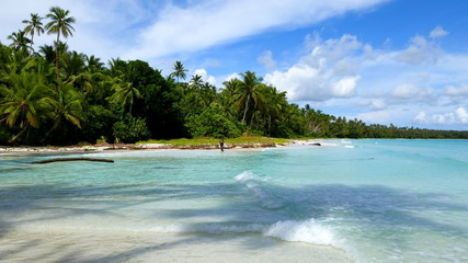traumhafte Meeresbucht mit weißem Sandstrand und grünen Palmen