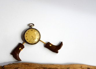 in Eile, symbolisches Bild einer alten Taschenuhr mit Beinen und Cowboystiefel