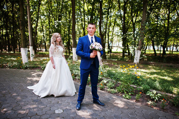 Happy wedding couple in love at park on sunny day.