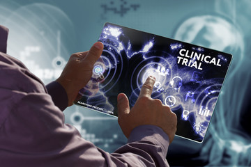 Business, Technology, Internet and network concept. Young businessman working on a virtual screen of the future and sees the inscription: Clinical trial