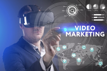 Business, Technology, Internet and network concept. Young businessman working in virtual reality glasses sees the inscription: Video marketing