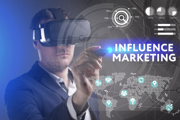 Business, Technology, Internet and network concept. Young businessman working in virtual reality glasses sees the inscription: Influence marketing