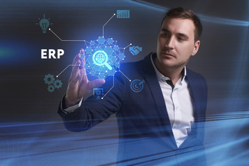 Business, Technology, Internet and network concept. Young businessman working on a virtual screen of the future and sees the inscription: ERP
