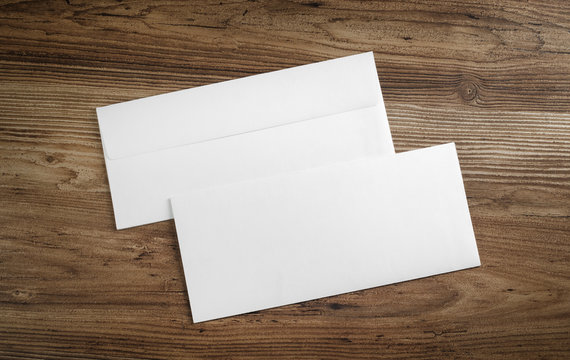 Blank paper envelopes on wooden table background. Front and back side. Template for your design. Top view.