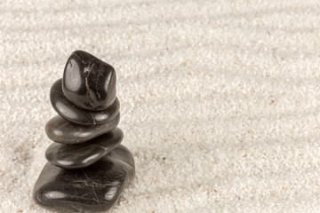 Fototapeta na wymiar empilement de galets sur sable, symbole du zen et du bien-être