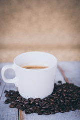 cup of coffee on old wooden desk. Simple workspace or coffee break in morning/ selective focus