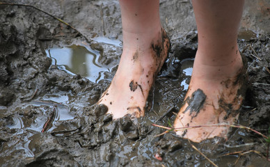 Young kid's muddy feet. Selective focus.