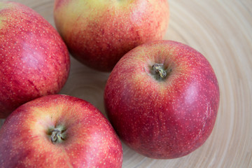 Beautiful red apples in a wooden plate