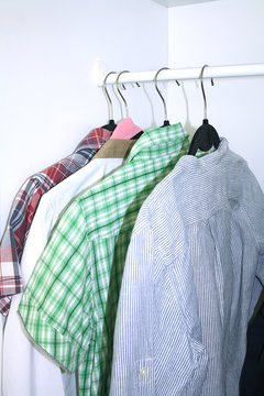 clean clothes hanging on hangers in the closet