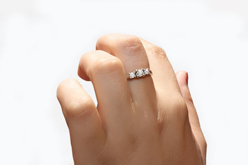 female hand with a ring of white gold and diamonds on a white background