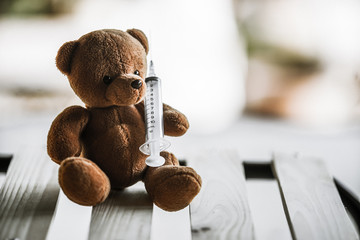 bear doll and syringe with dramatic tone