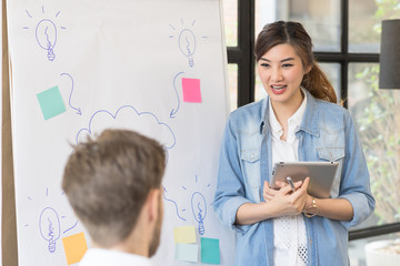 Young asian charming woman making presentation about new idea by brainstorming meeting in modern office.