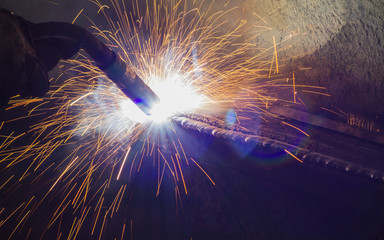 Closeup welding steel by MIG/MAG weld (Argon welding) in industrial factory. - obrazy, fototapety, plakaty