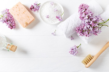 Fototapeta na wymiar Natural bath salt, soap, cotton towels and lilac flowers (symbolic image)