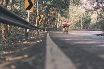 Asian men are cycling road bike morning uphill on the road