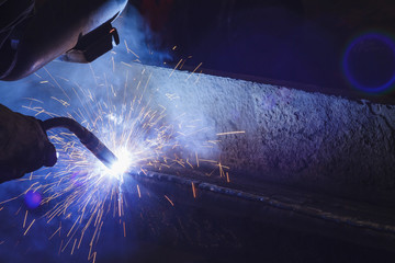 Fototapeta na wymiar Worker welding steel by MIG/MAG weld (Argon welding) in industrial factory .