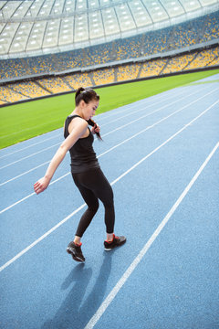 Young asian sportswoman sprinting on running track stadium