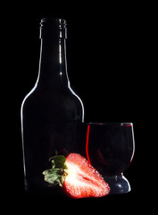 Glass and bottle wine on black background