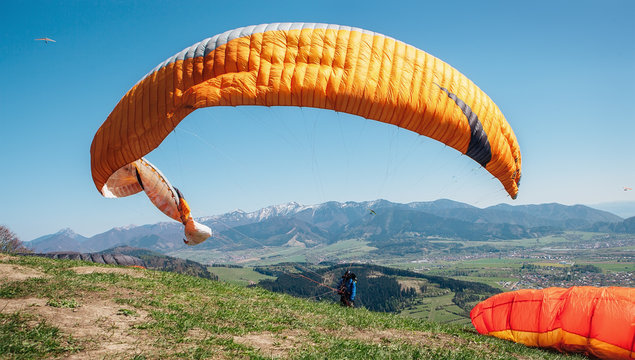 Paraglider catch a wind with his paraplane