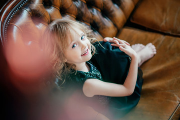 portrait of cute girl sitting on the couch/happy day